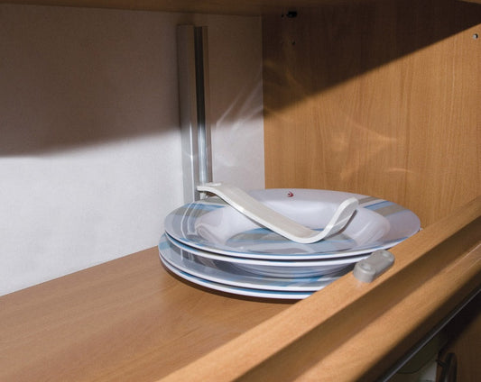 tallerkenholder festet i skinne holder 2 dype og 2 flate tallerner på plass i et skap