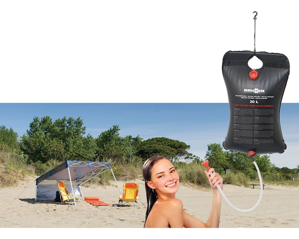 bærbar solardusj i bruk av en kvinne på en strand