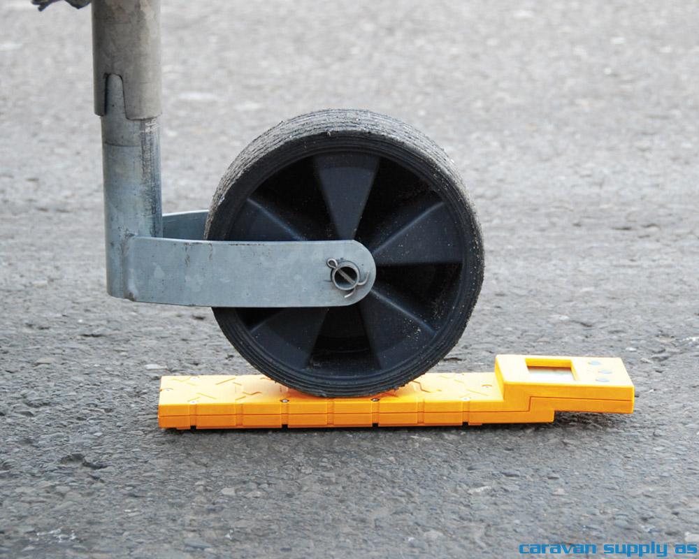 fronthjul plassert på en orange cwc vekt på en grå betongunderlag