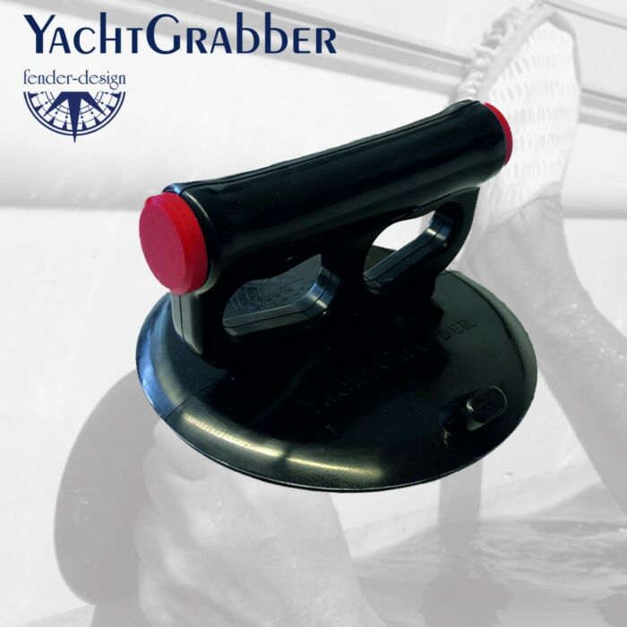 sort yacht crabber med røde utløsningsknapper i forkan og et bårskrog i bakgrunn som blir vasket