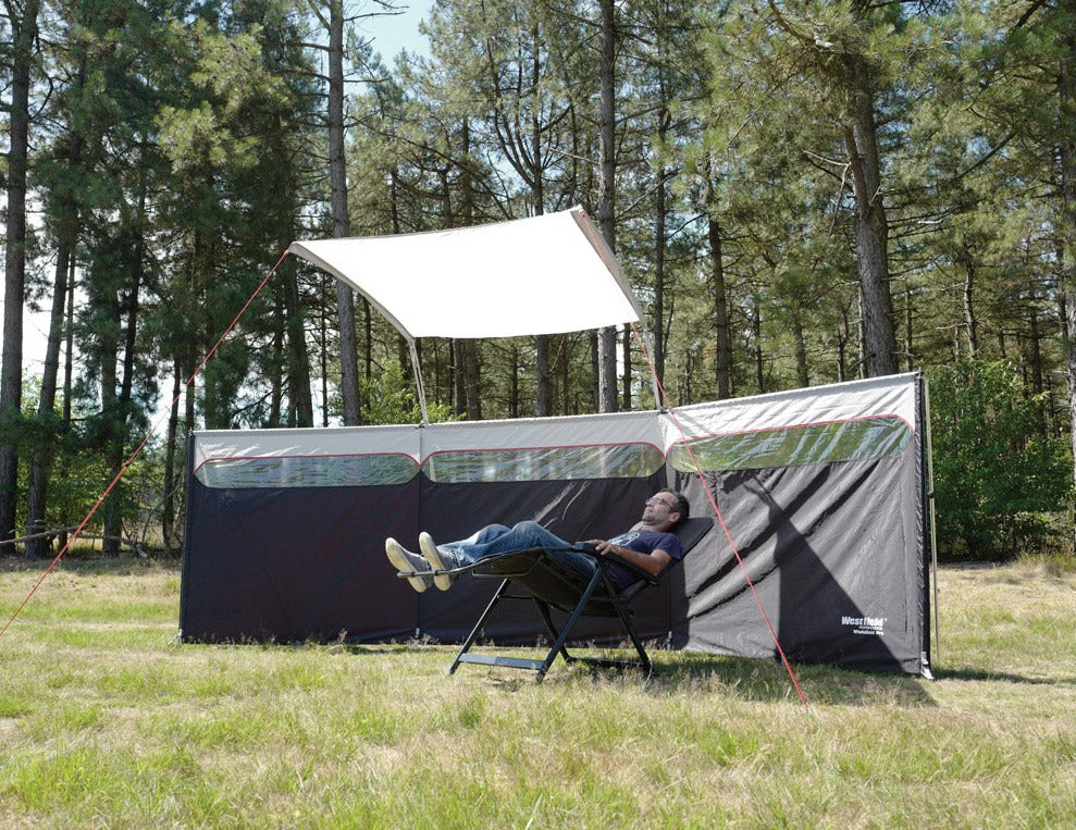 levegg med tak og en mann liggende i campingstol under leveggtaket