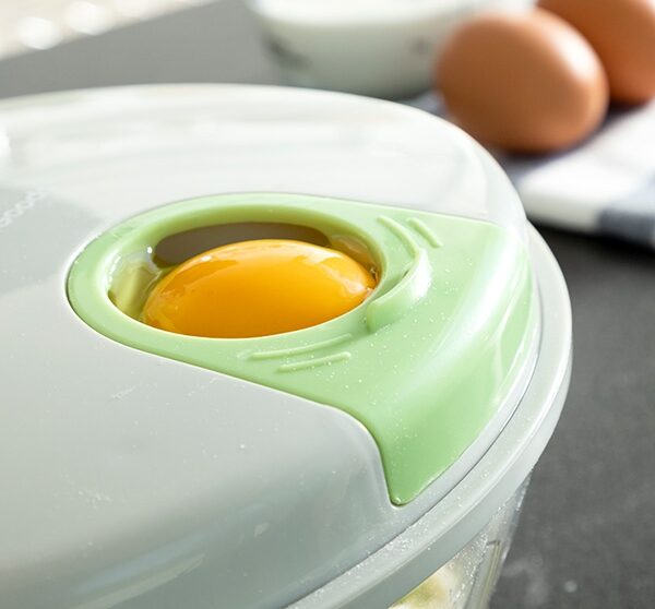 kjøkkenmaskinens smarte påfylningsmulighet vist med et egg