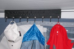 knaggrekke med e3n blå, en rød jakke, og en hvit caps hengende
