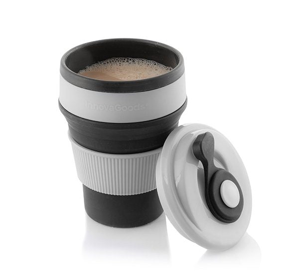 sammenleggbar silikonkopp fylt med kaffe og lokk lent til koppen