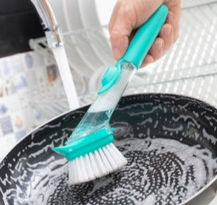 oppvaskbørste med såpe vasker en panne