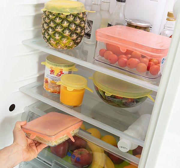 gjenbrukbare og regulerbare lokk festet til ulike beholderstørrelse plassert i et kjøleskap